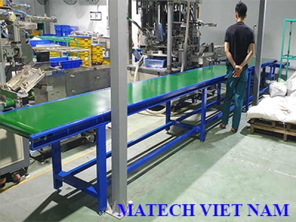 Băng tải PVC khung nhôm có bàn thao tác công nhân hai bên do Matech Việt Nam sản xuất
